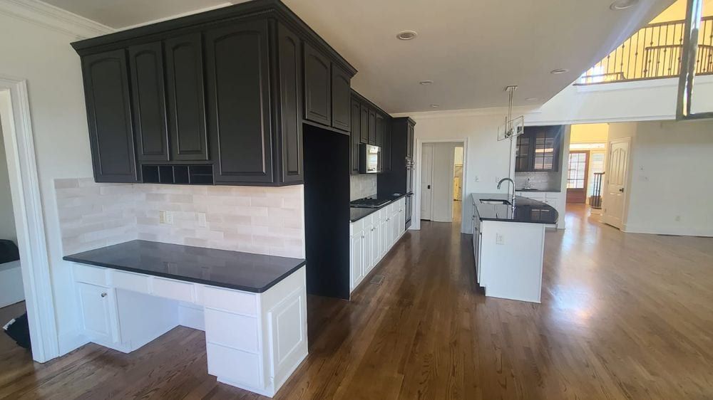 Kitchen with black upper cabinets and a white built-in desk