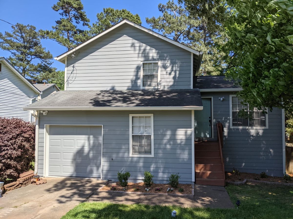 Light blue-gray house with a single garage and wooden front steps