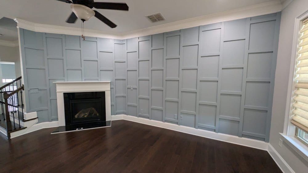 Living room with a blue-gray box-molding accent wall around a white fireplace