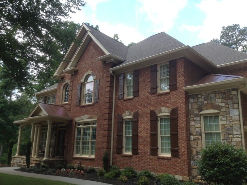 Red brick and stone two-story house with white trim
