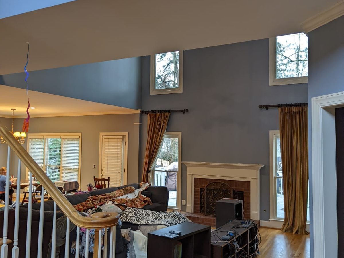 Two-story family room with gray walls, a staircase, and a balcony above