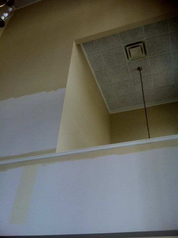 Upper foyer wall under a skylight, primed white below the balcony