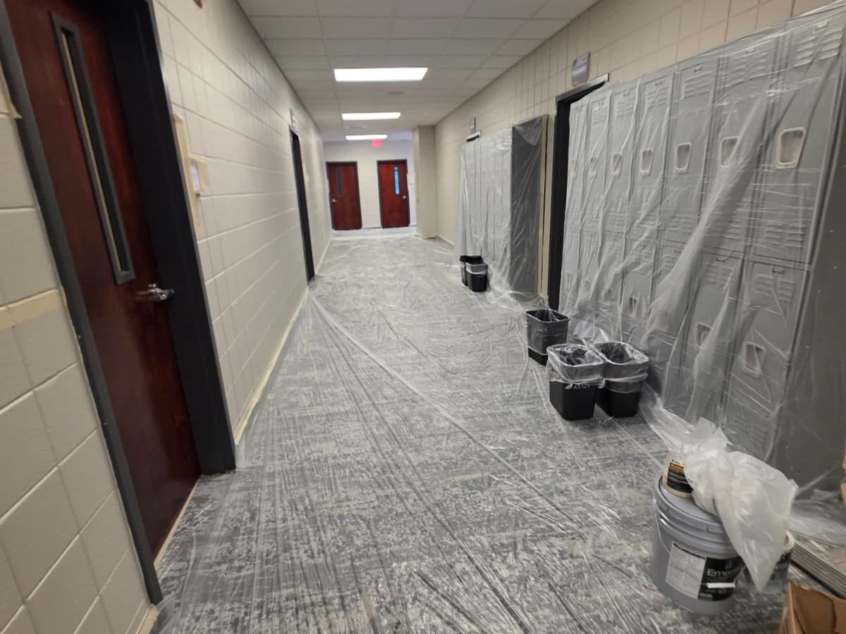 Church hallway with the floor covered in protective paper and the walls masked before painting