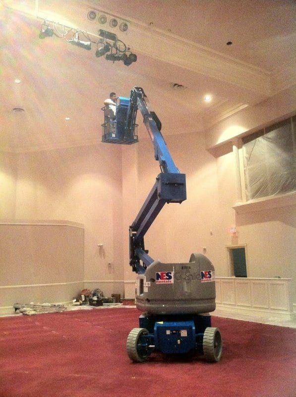 Lift raised toward the ceiling in a church sanctuary with red carpet