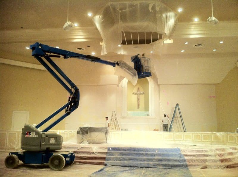 Lift raised in a church sanctuary, with a cross above the altar