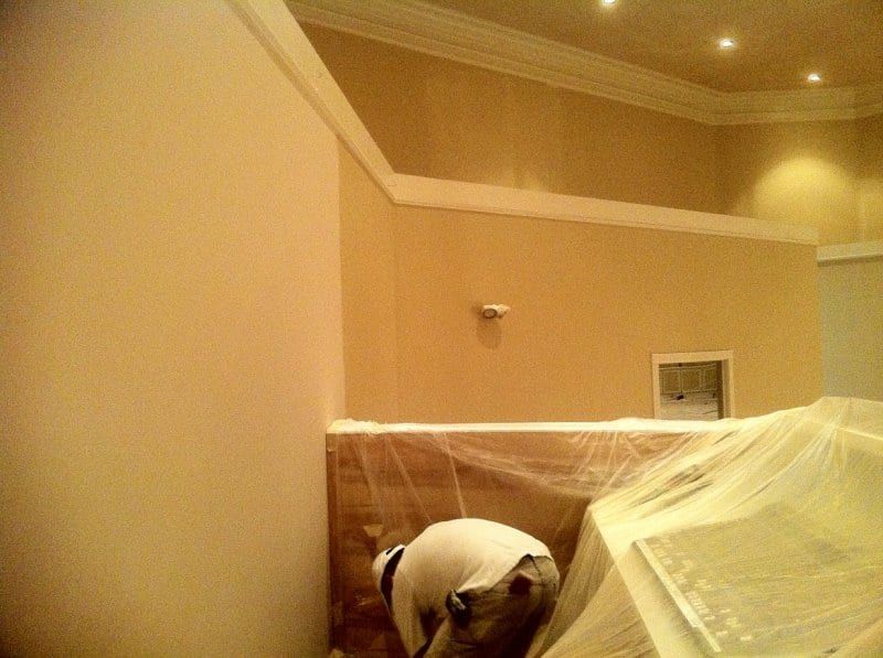 Painter masking the lower sanctuary wall with plastic