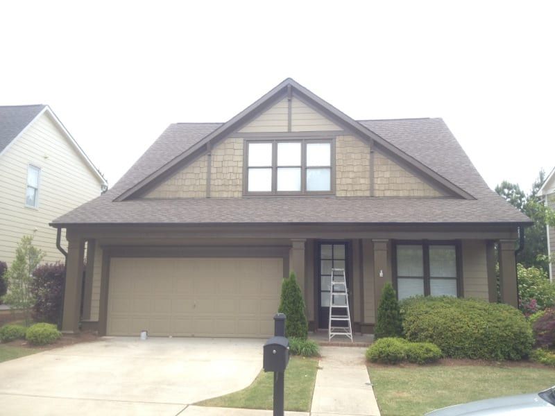 Craftsman house with tan siding and a ladder by the front door