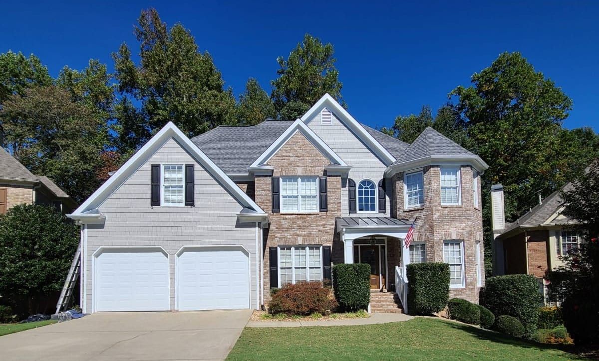 The same house painted light gray, with white trim and black shutters