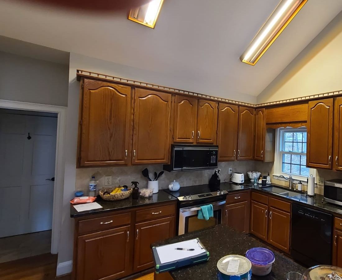 Kitchen with dark stained wood cabinets and black counters