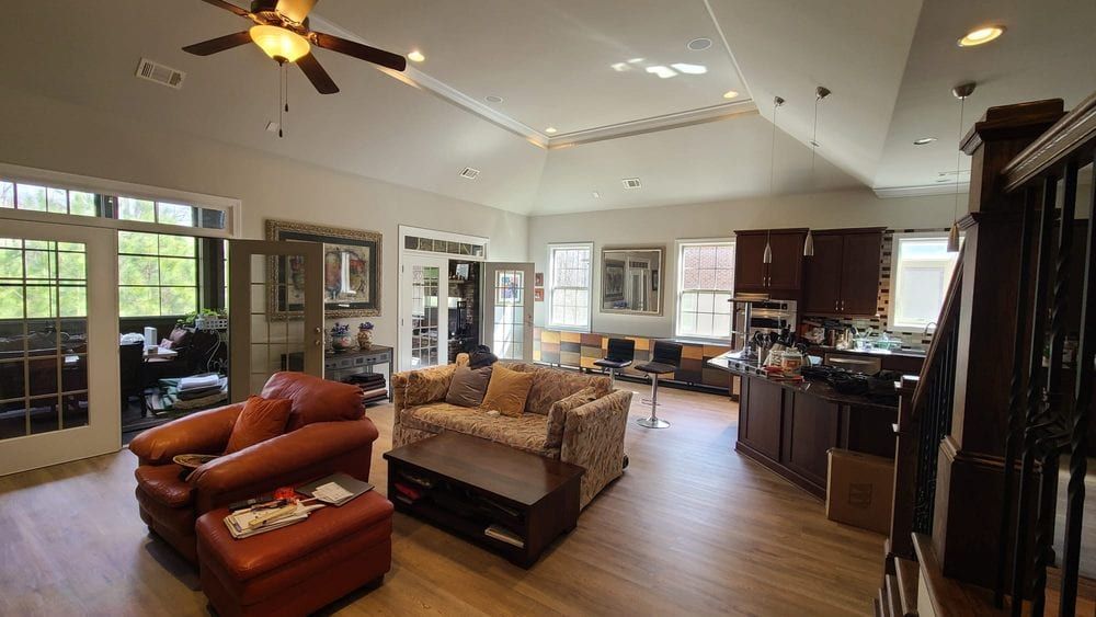 Open living room with orange leather chairs, a sofa, and a vaulted ceiling