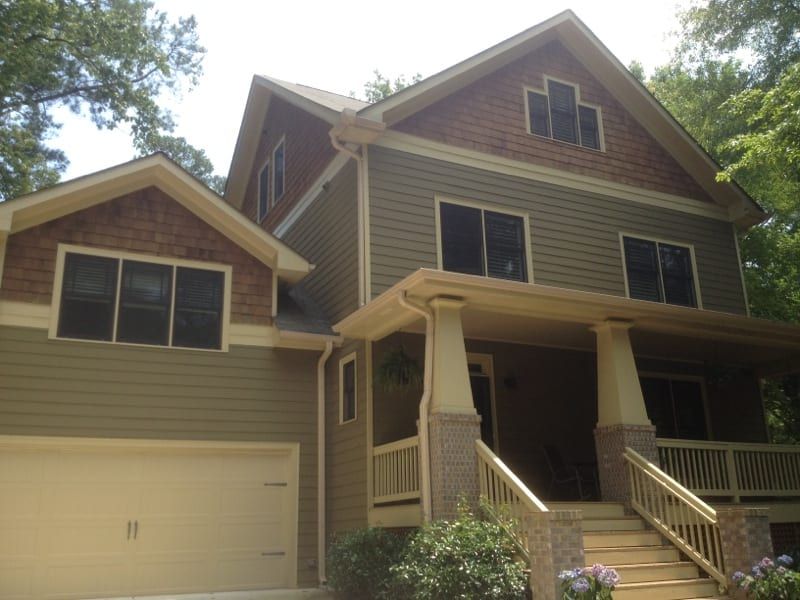Craftsman house with olive siding, stone columns, and a front porch