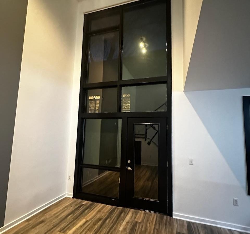 Tall black-framed window in a fresh white wall with a gray accent