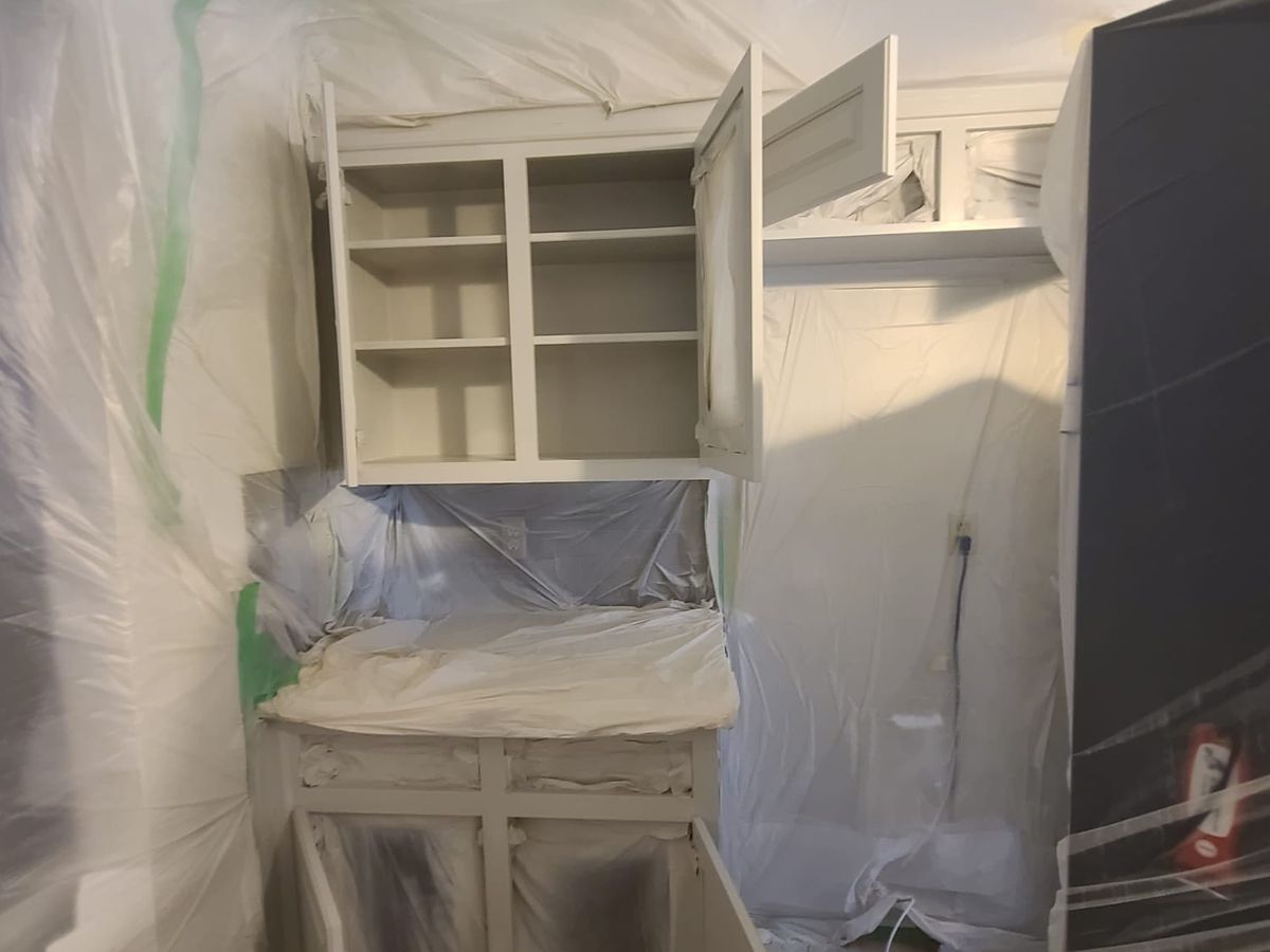 Built-in hutch and cabinets masked off with plastic before painting