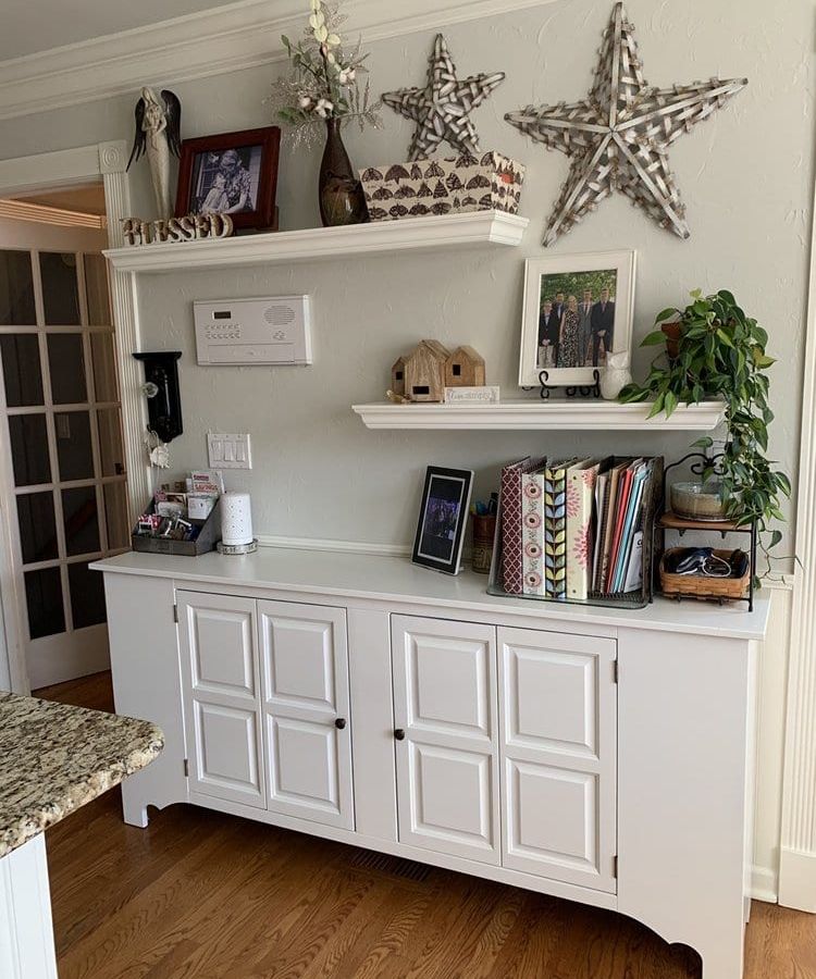 White hutch with open shelves and decor against a white wall